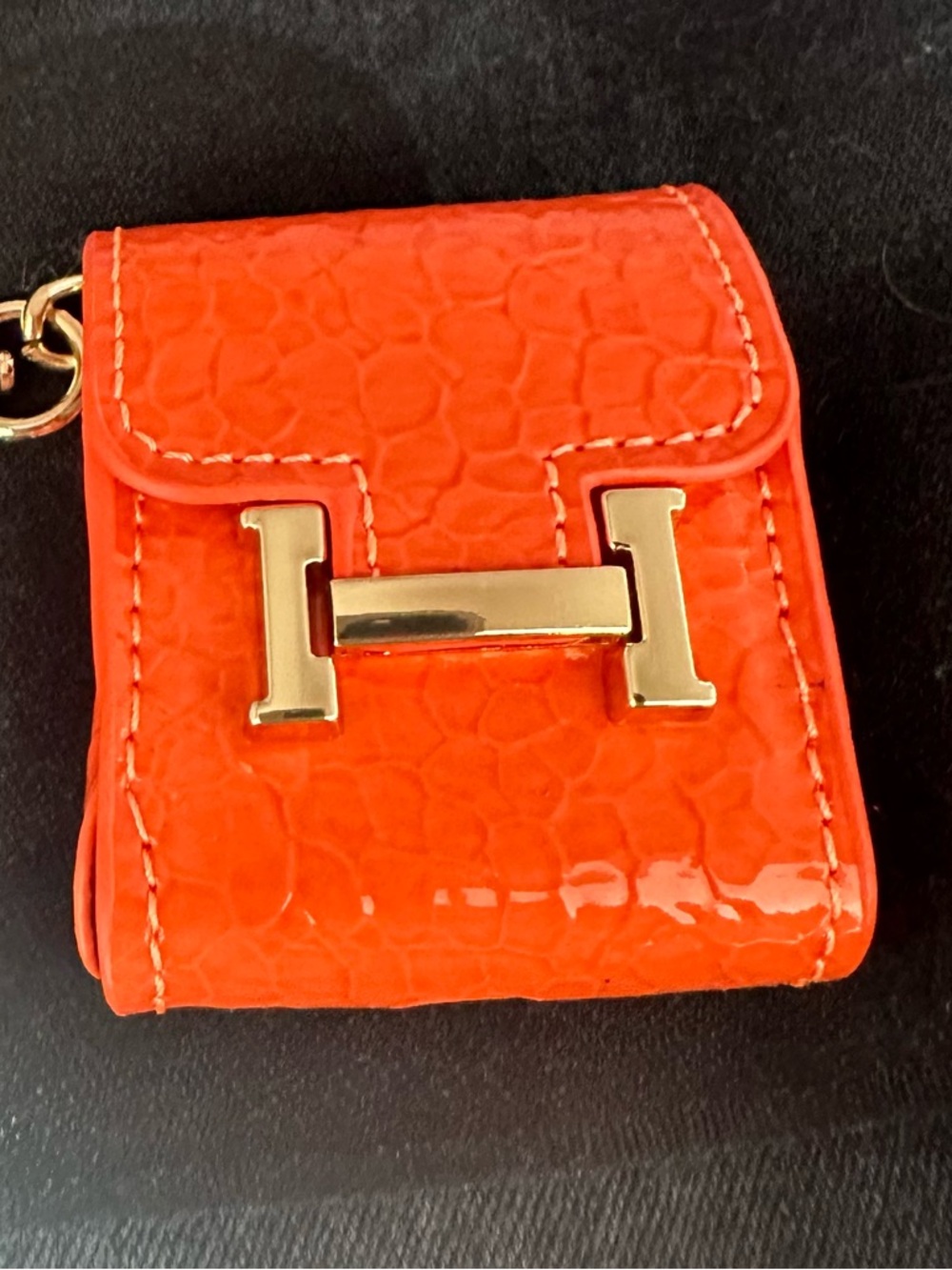 Orange ear bud holder keychain with Gold H Accent. New